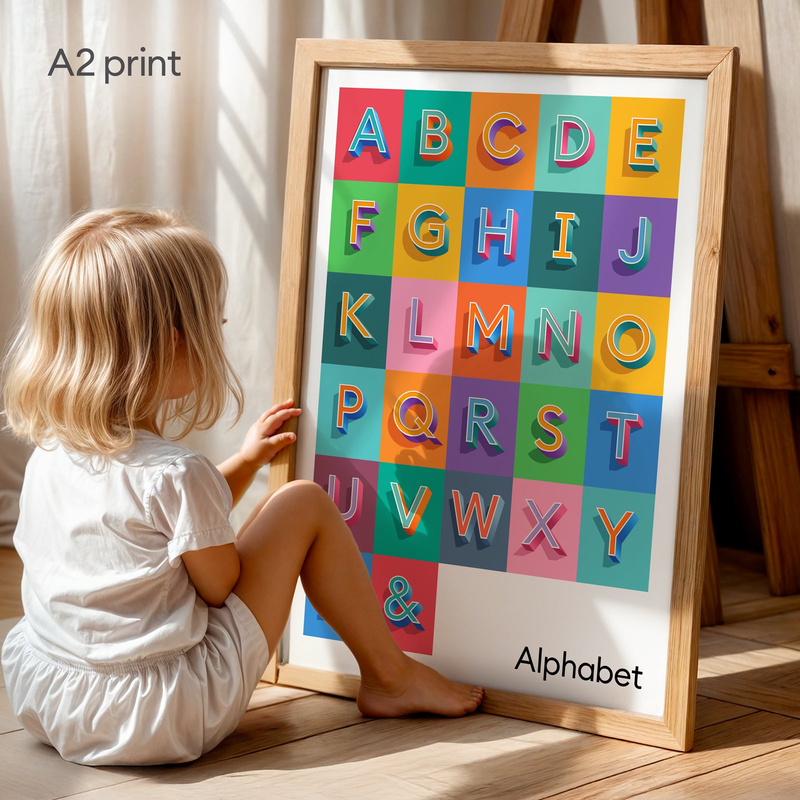 A bold and colourful Alphabet Print from Alf and Bet shown in a child’s bedroom